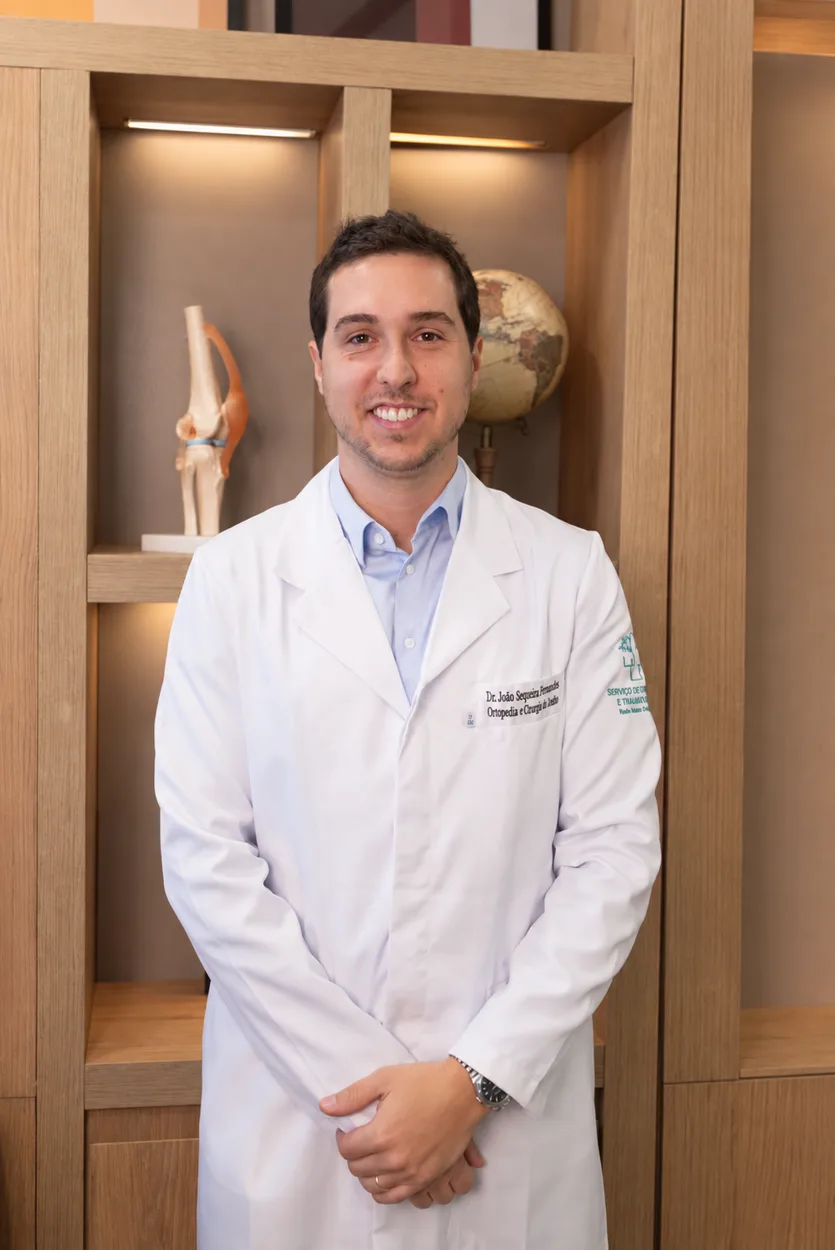 Dr. João Sequeira, ortopedista com atuação em cirurgia do joelho em Belo Horizonte, em pé no consultório